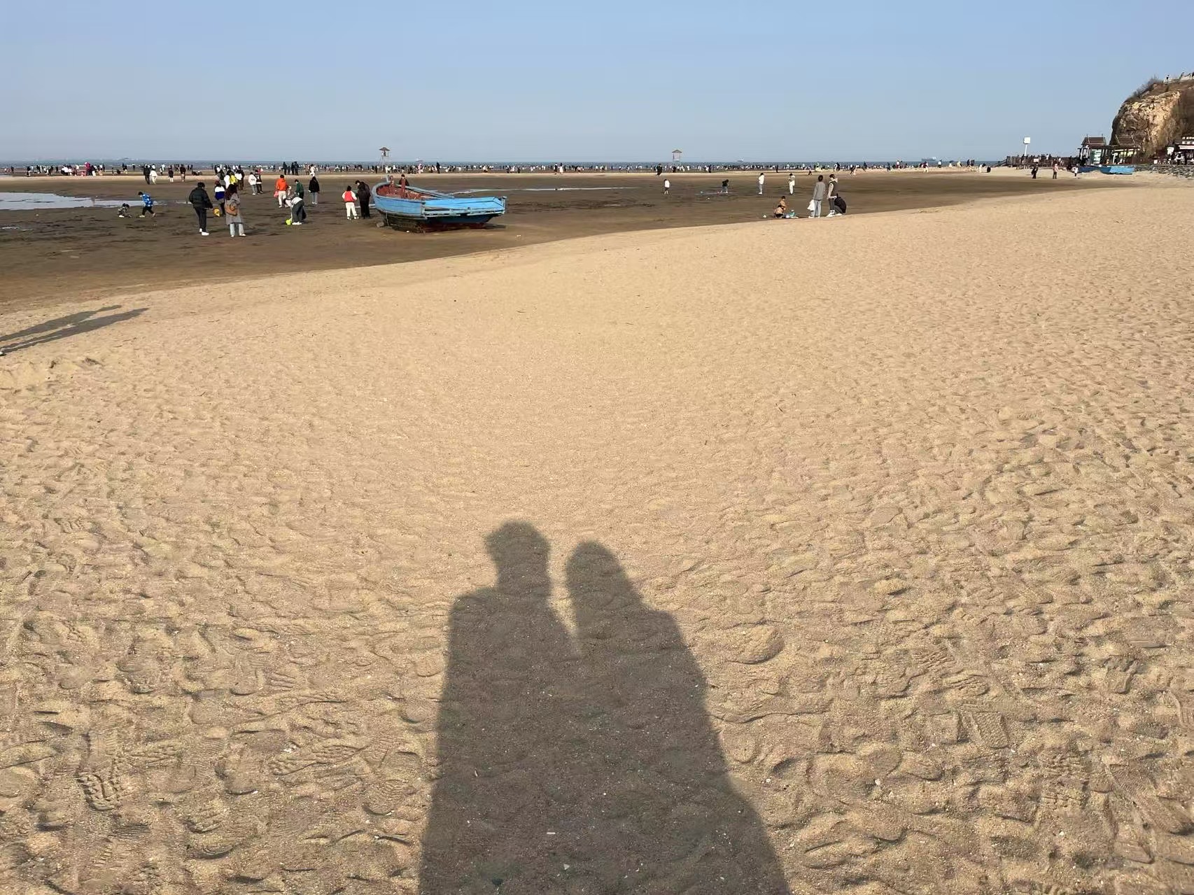 海边沙滩上两个人依偎的影子