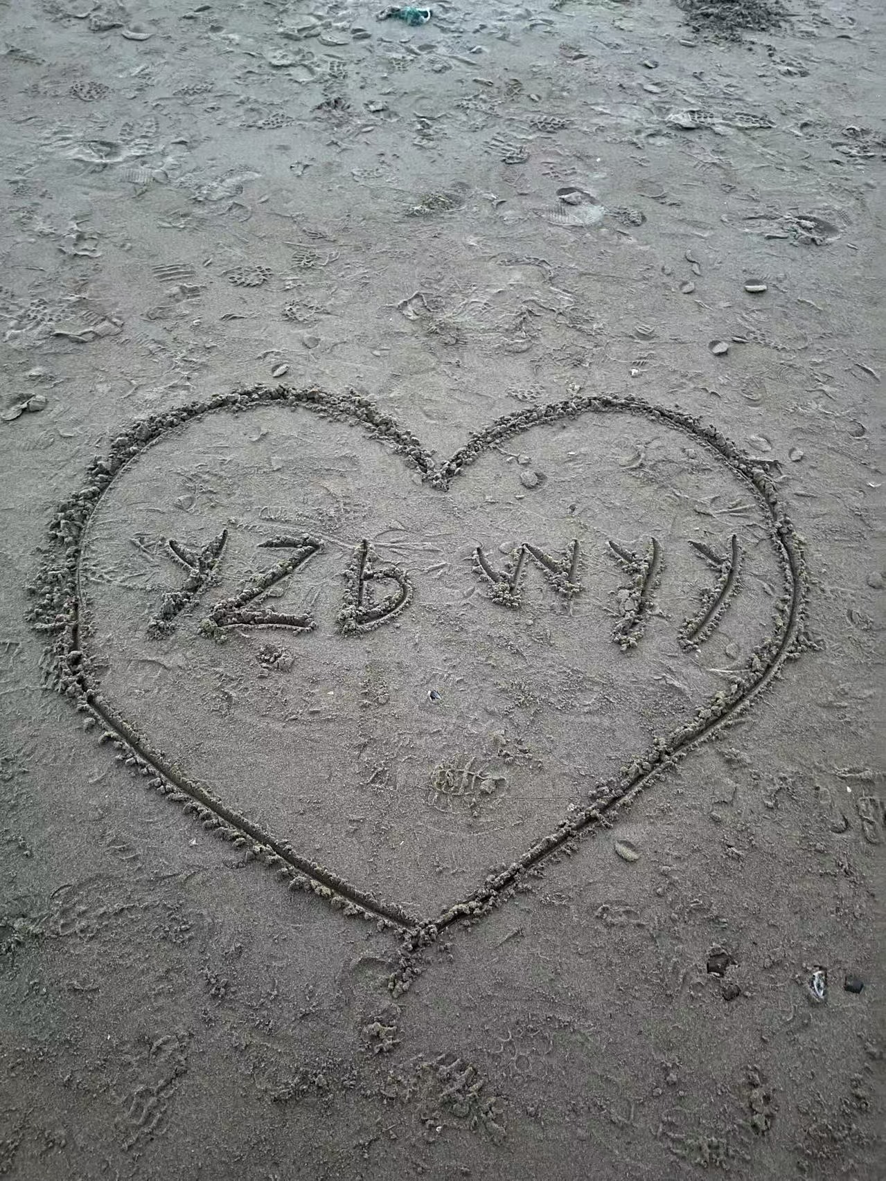 沙滩上画着 YZB WYY 的爱心